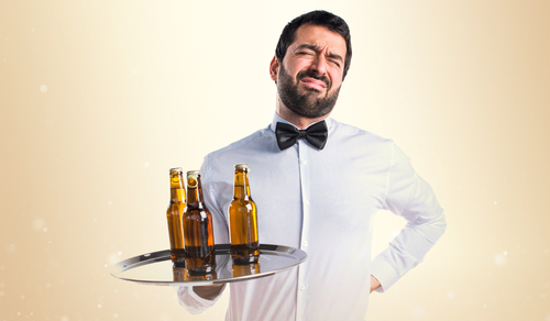 waiter carrying tray with hand on back in pain