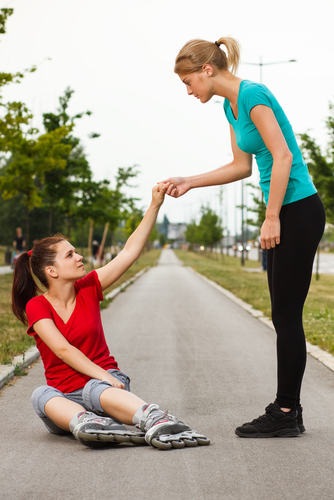 mother helping fallen daughter up