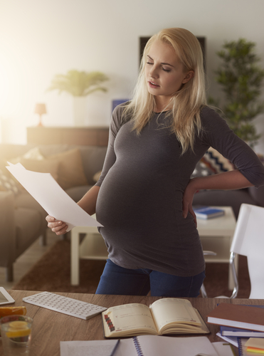 pregnant woman with proper posture looking at paper