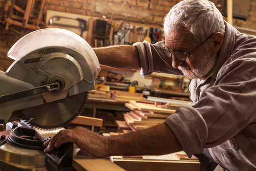 carpenter using saw to cut wood