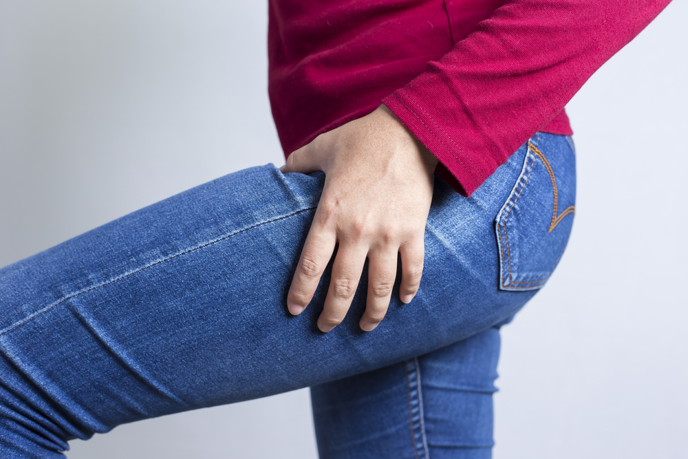 Woman holding her thigh in pain