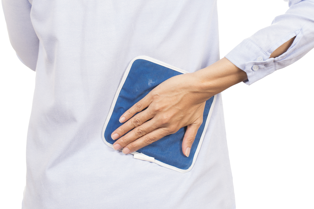 a person holding an ice pack on their back for cold pack therapy