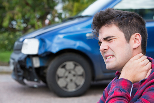 man holding neck after car accident