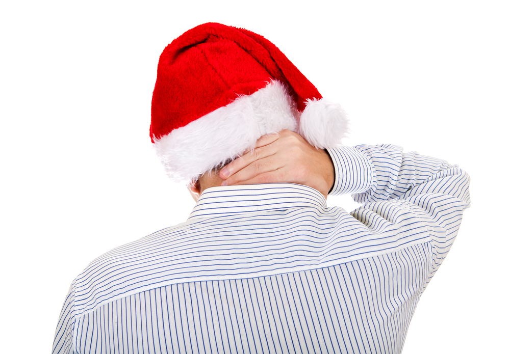 man with santa hat holding his neck